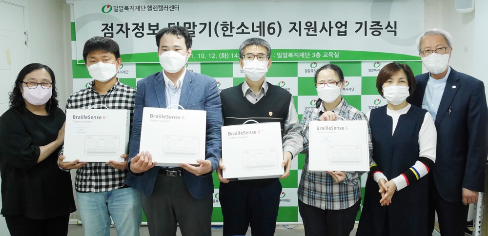 12일 진행된 전달식에서 시청각장애인 당사자와 밀알복지재단 관계자가 기념촬영을 하고 있다.jpg