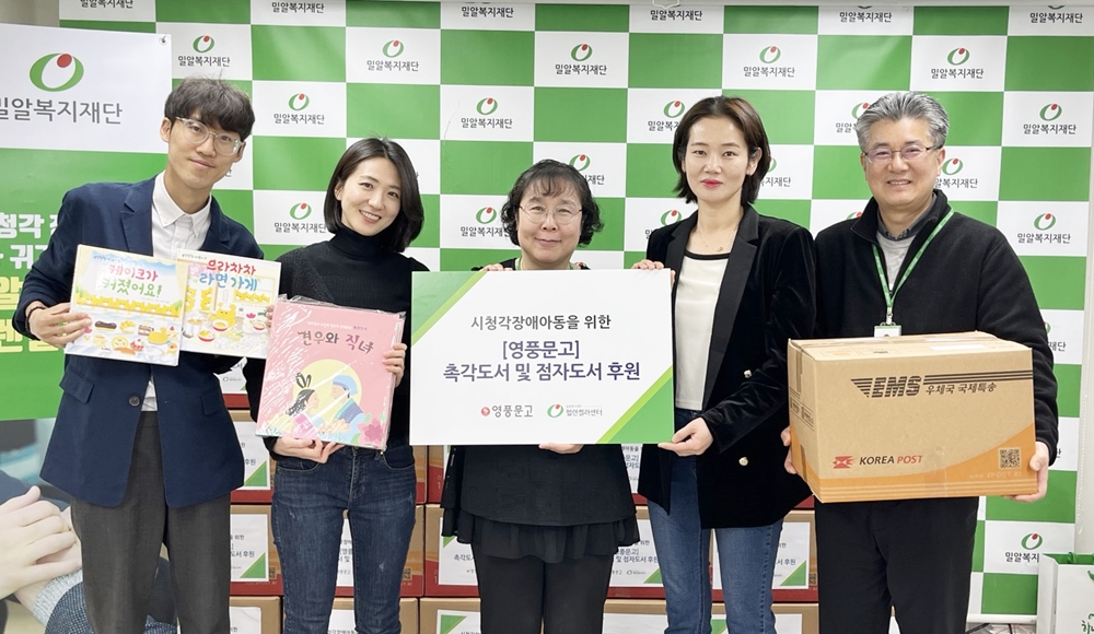 밀알복지재단 헬렌켈러센터 관계자와 시청각장애아동 어머니(오른쪽에서 두 번째)가 5일(수) 촉각도서와 점자도서를 전달받고 있다..jpg